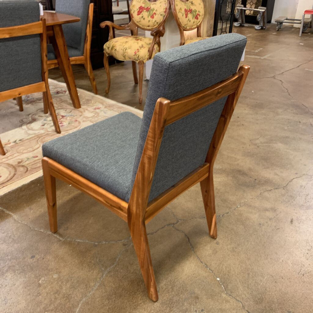 Chair with wooden frame and gray cushion on a concrete floor