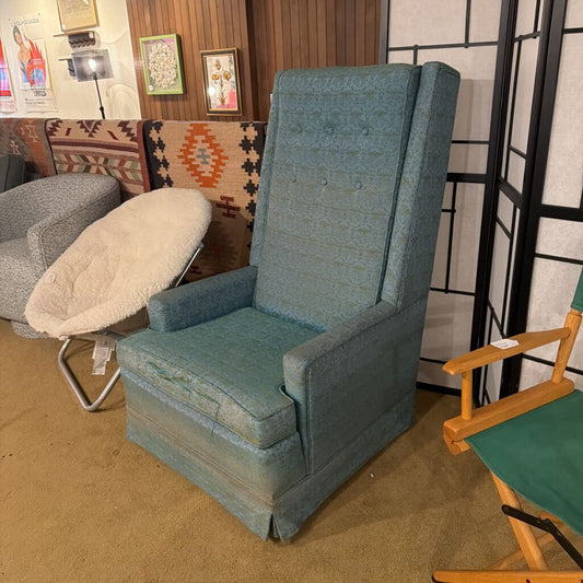 Blue armchair in a room with other furniture and decor