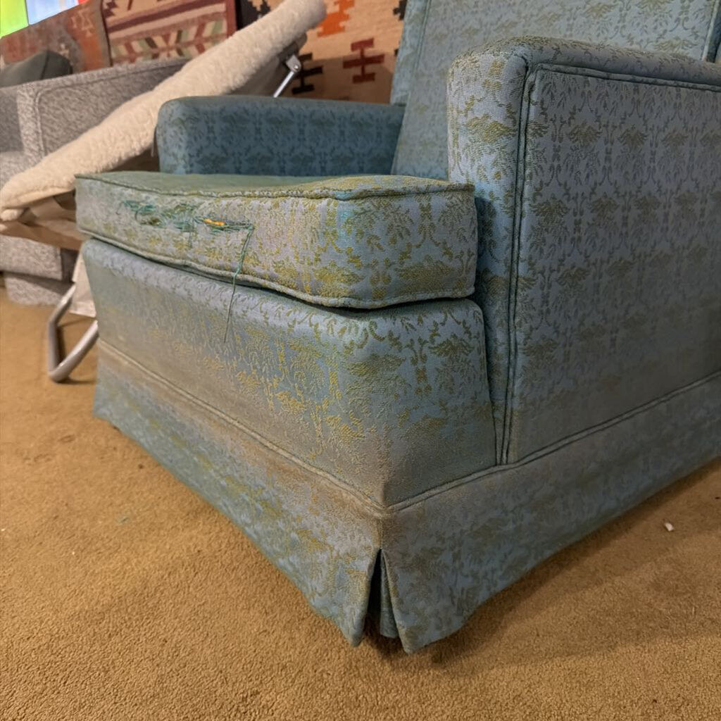 Patterned sofa with a cushion on a carpeted floor