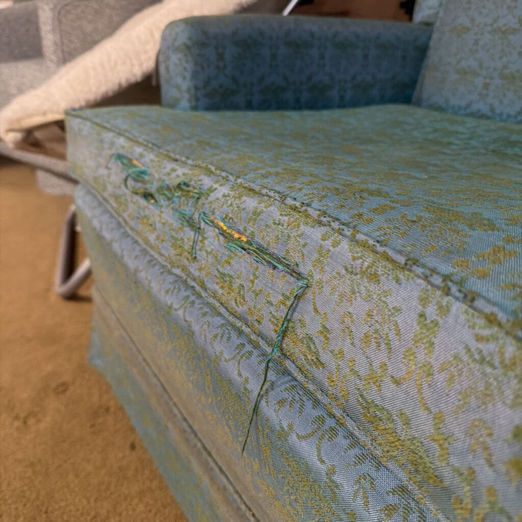 Vintage floral-patterned sofa with visible wear and tear