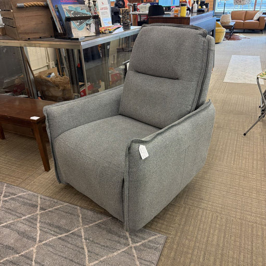 Gray armchair in a store setting with various items in the background