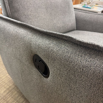 Gray textured armchair with a visible brand logo on a blurred background