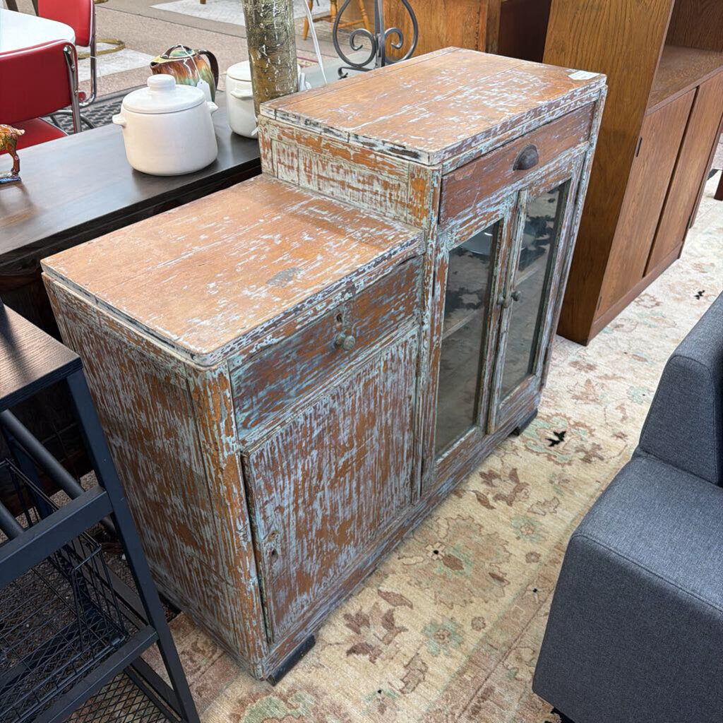 Vintage wooden sideboard with peeling paint in a room setting