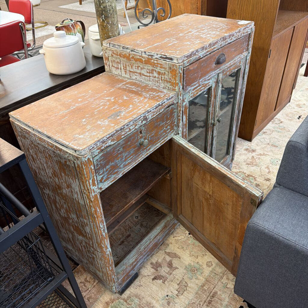 Vintage wooden cabinet with peeling paint in a room setting