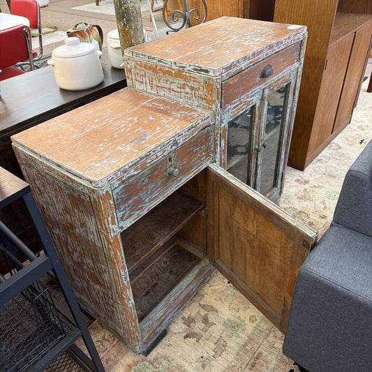 Vintage wooden cabinet with peeling paint in a room setting