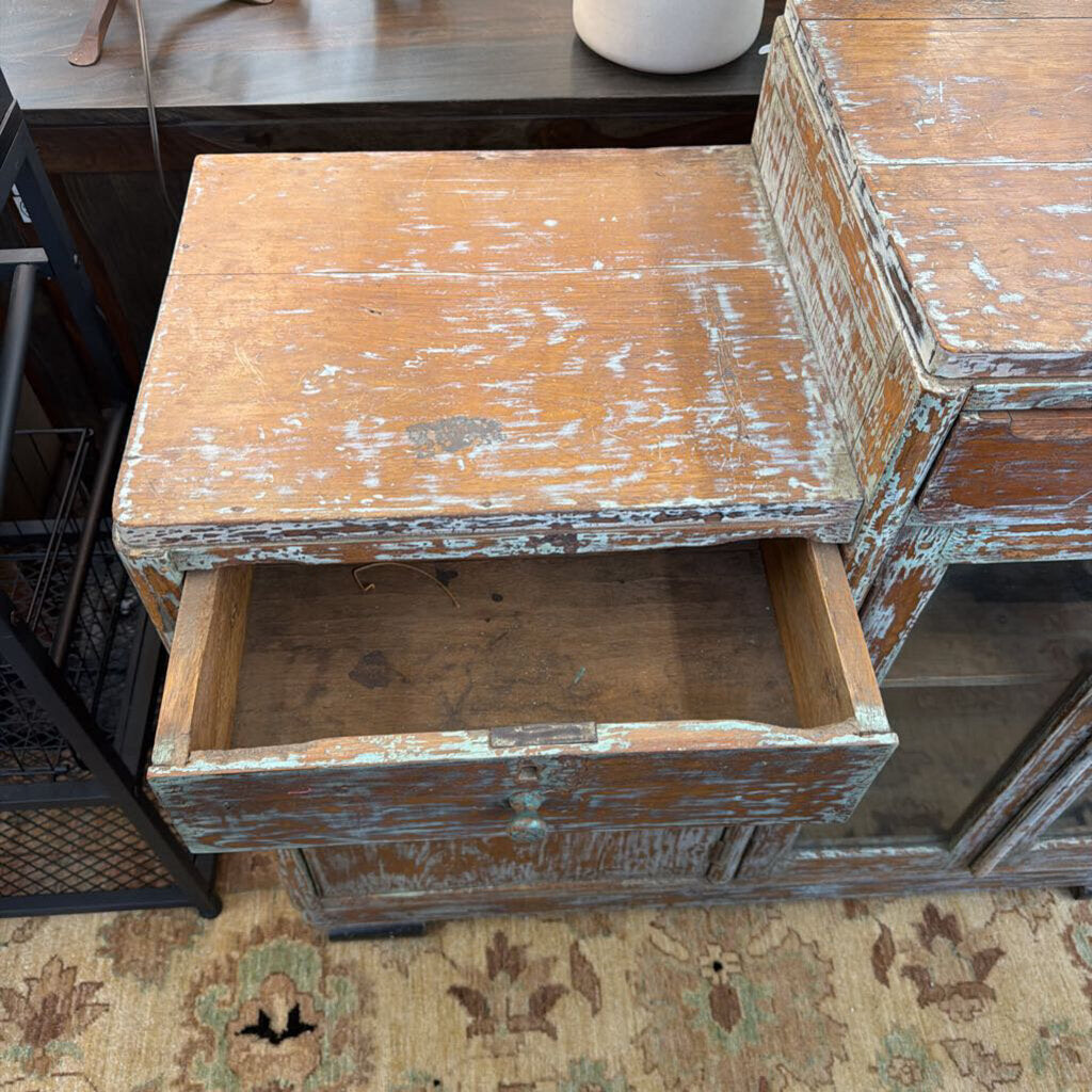 Vintage wooden side table with a drawer on a patterned rug