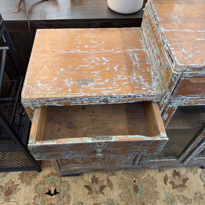 Vintage wooden side table with a drawer on a patterned rug