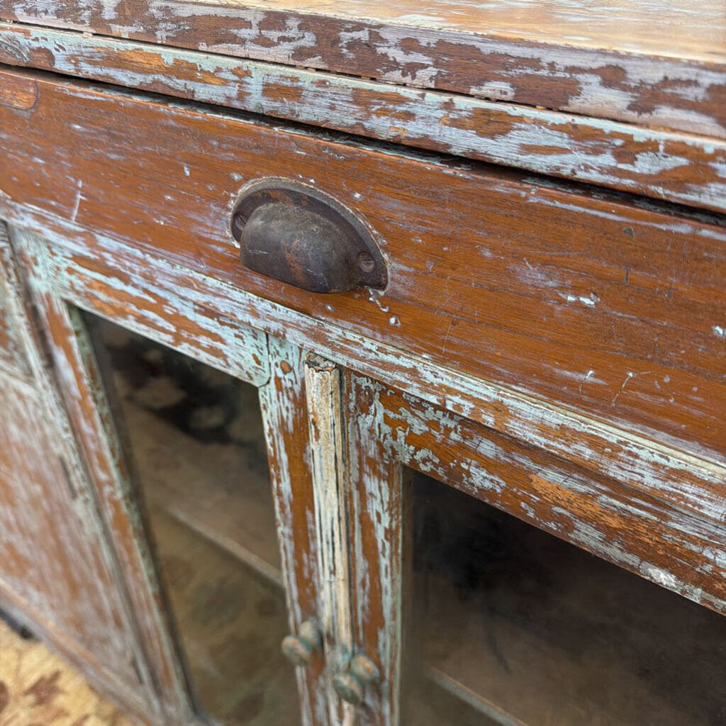 Close-up of a distressed wooden cabinet with peeling paint