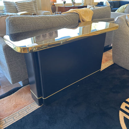 Navy blue console table with gold trim in a living room setting