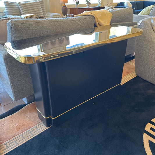 Navy blue console table with gold trim in a living room setting