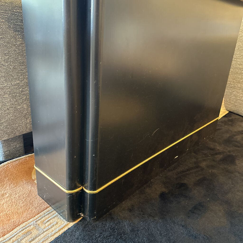 Black book with gold spine on a textured surface