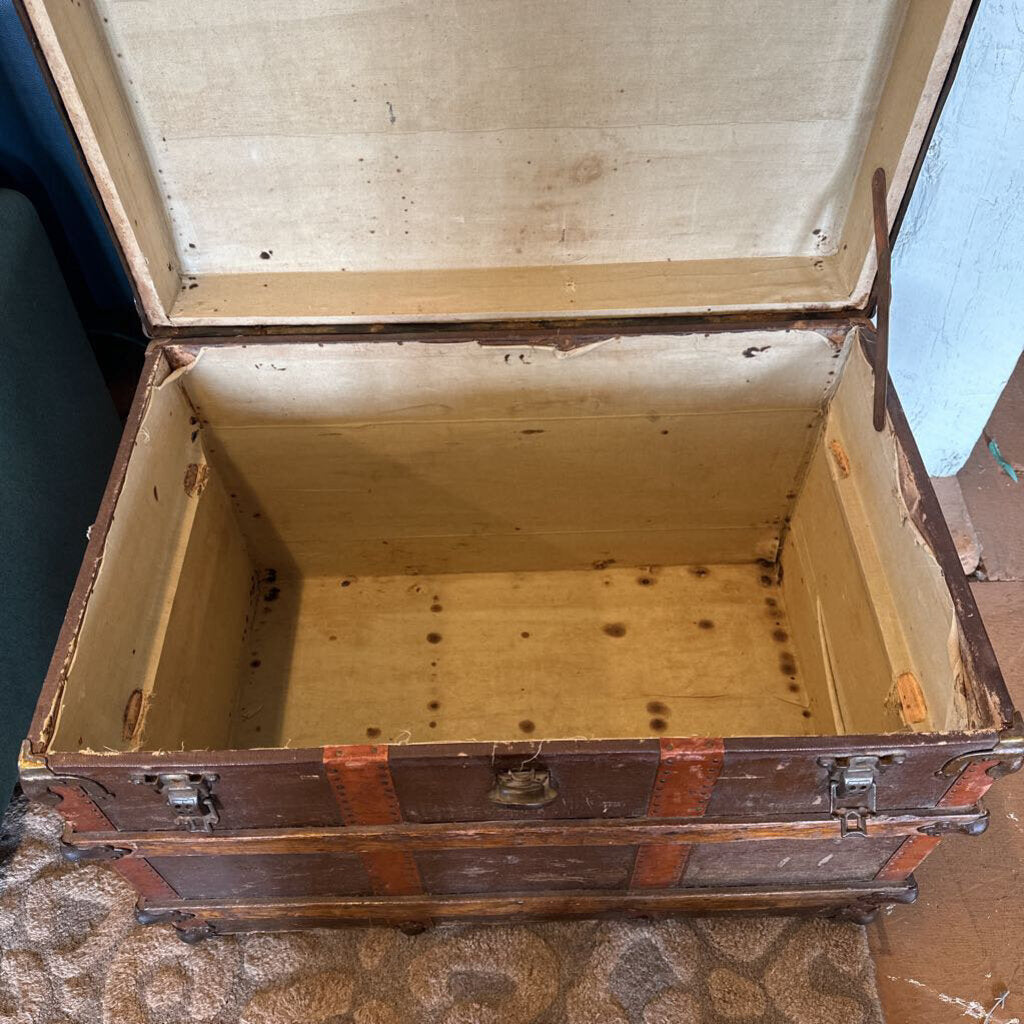 Old wooden trunk with a hinged lid on a textured surface