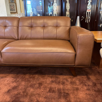 Brown leather sofa in a room with a rug and decorative items.