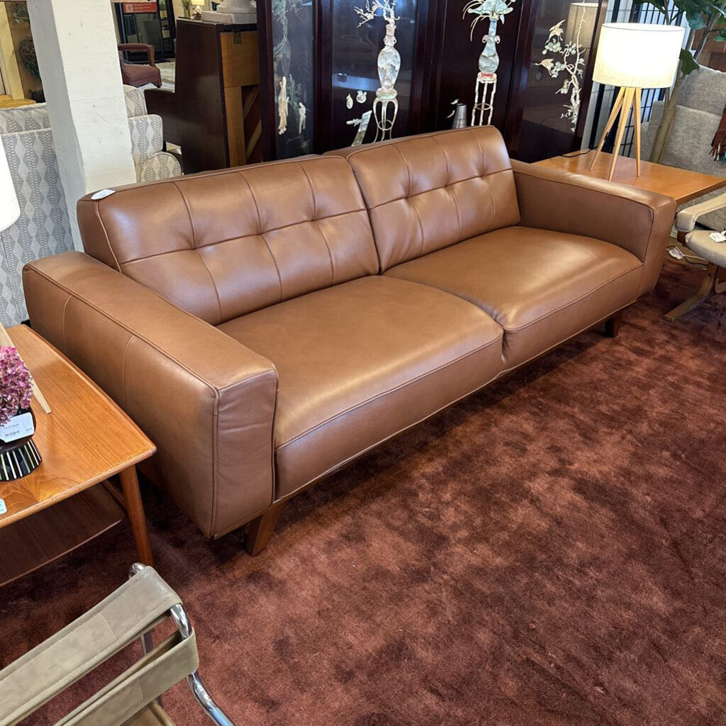 Brown leather sofa in a room with decorative elements.