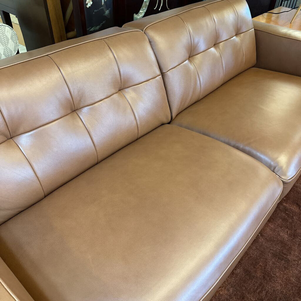Beige leather sectional sofa in a room setting