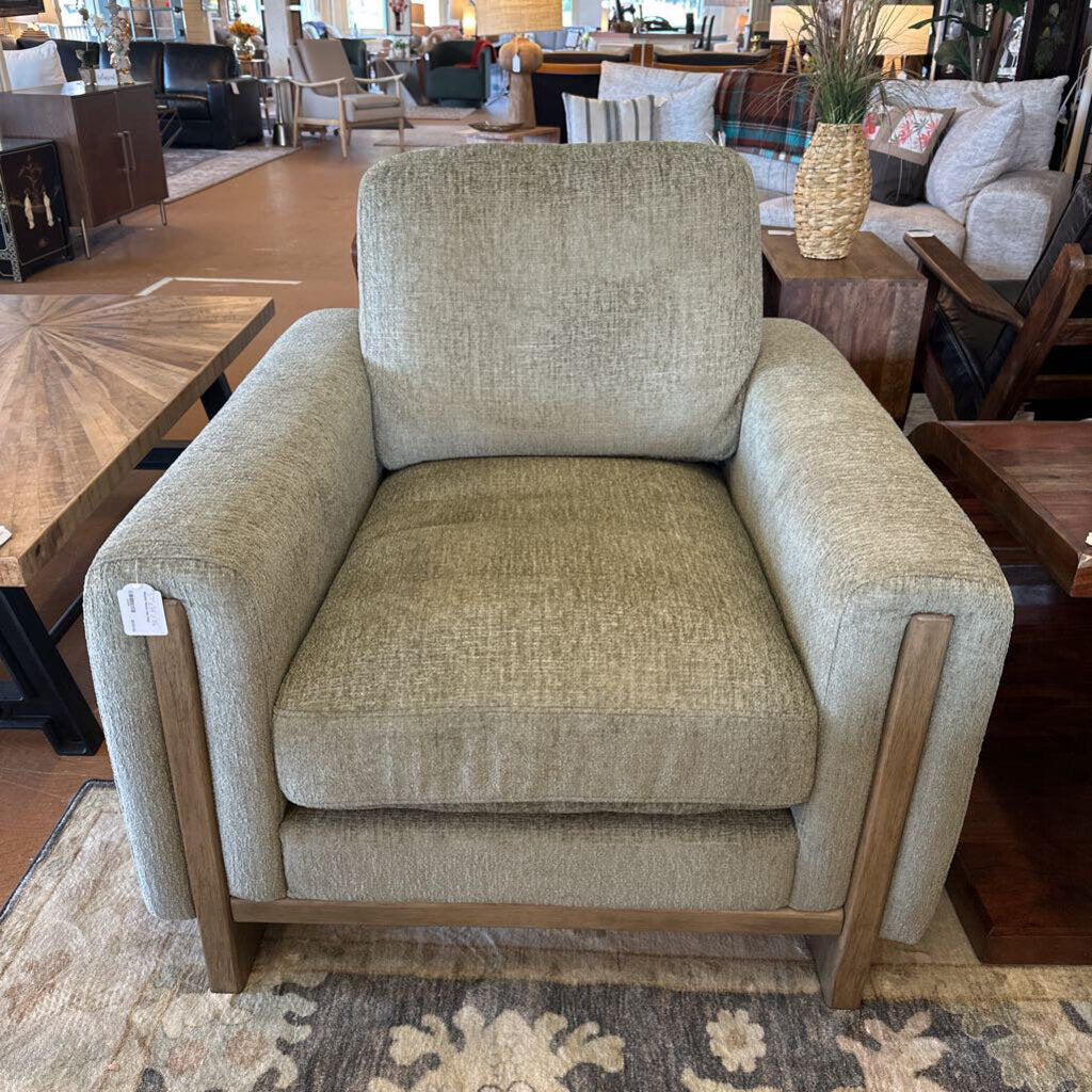Beige armchair in a furniture store setting with wooden legs