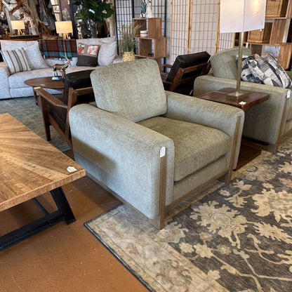 Gray armchair in a room with furniture and decor