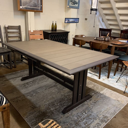 Dining room with a large wooden table and chairs on a patterned rug.