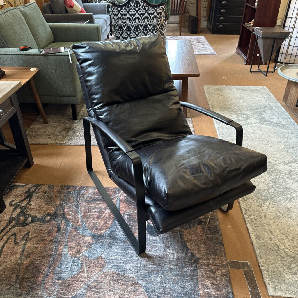 Black leather armchair in a room with furniture and decor