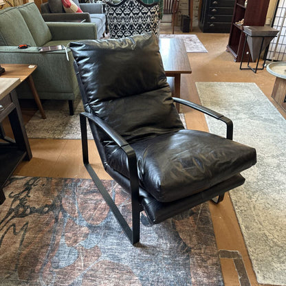Black leather armchair in a room with furniture and decor