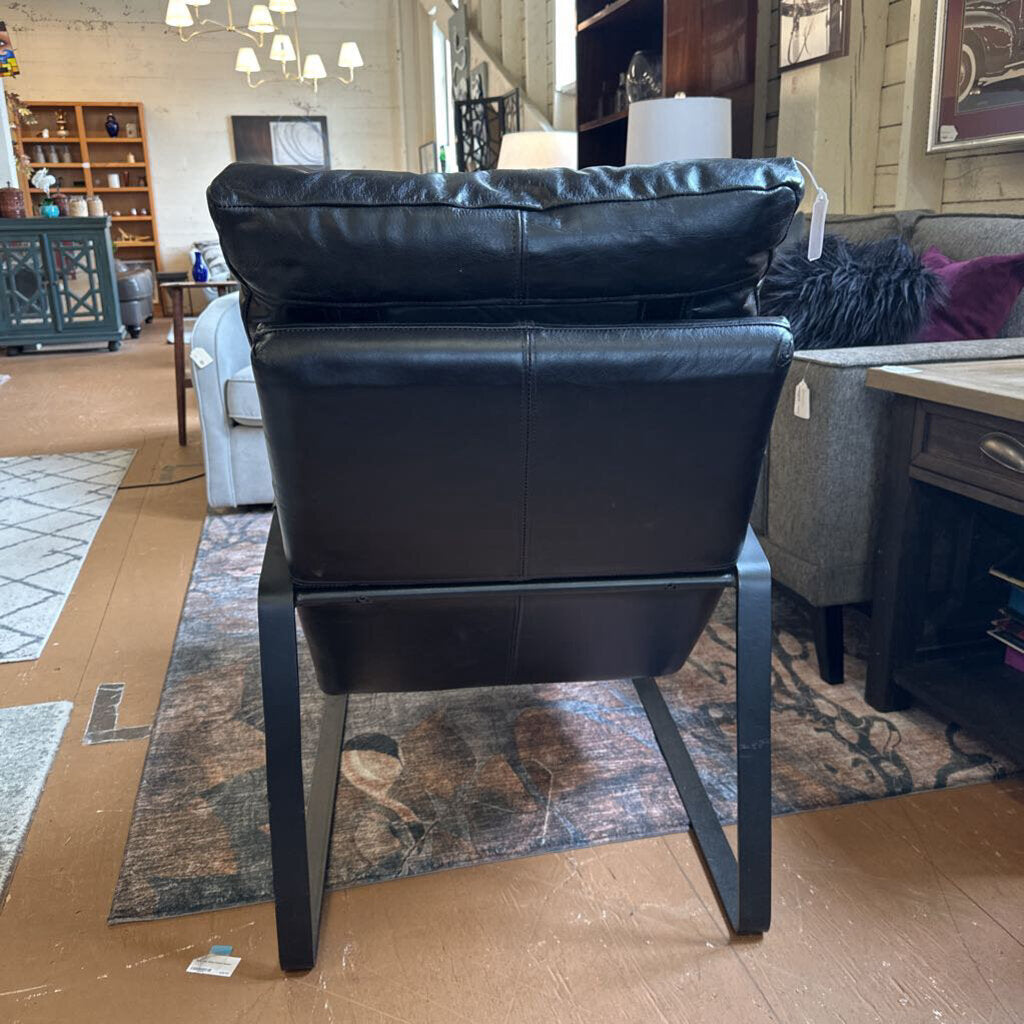 Black leather chair in a showroom setting with furniture and decor around