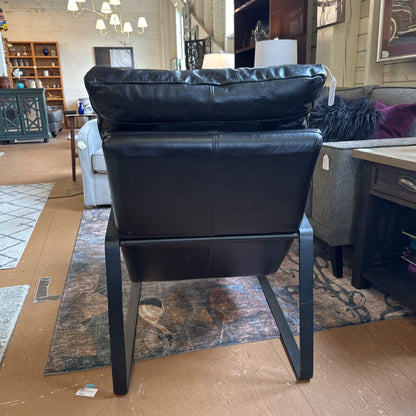 Black leather chair in a showroom setting with furniture and decor around