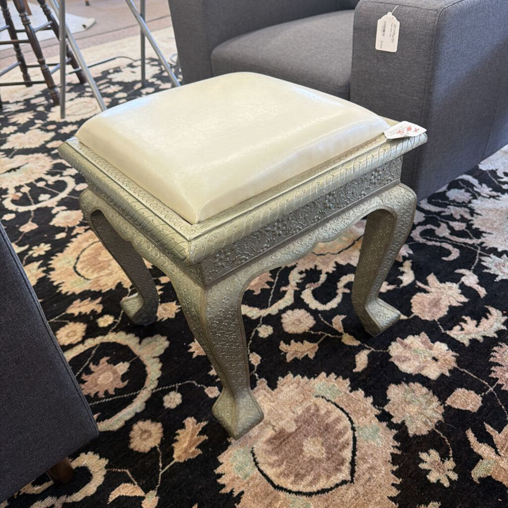 Small stool with a cushion on a patterned rug