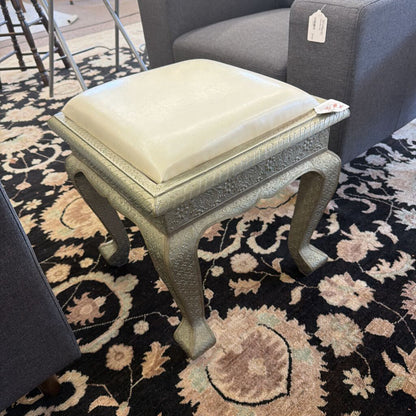 Small stool with a cushion on a patterned rug