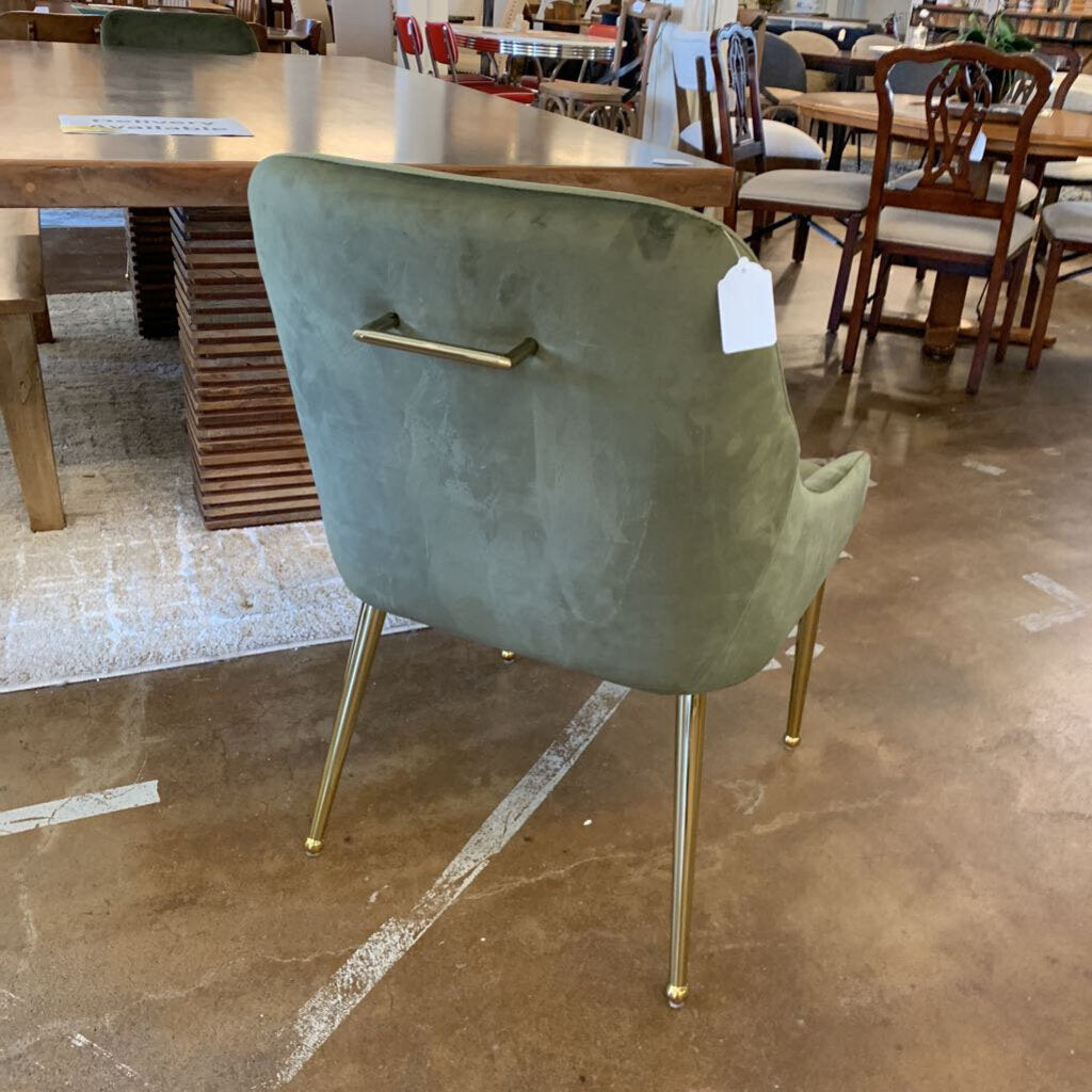 Green chair with gold legs in a showroom setting