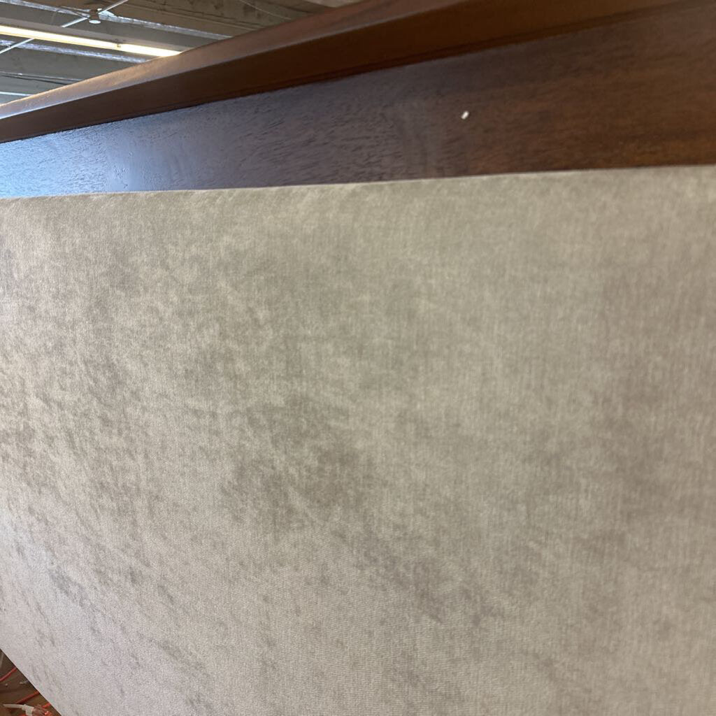 Close-up of a textured gray surface with a wooden frame above