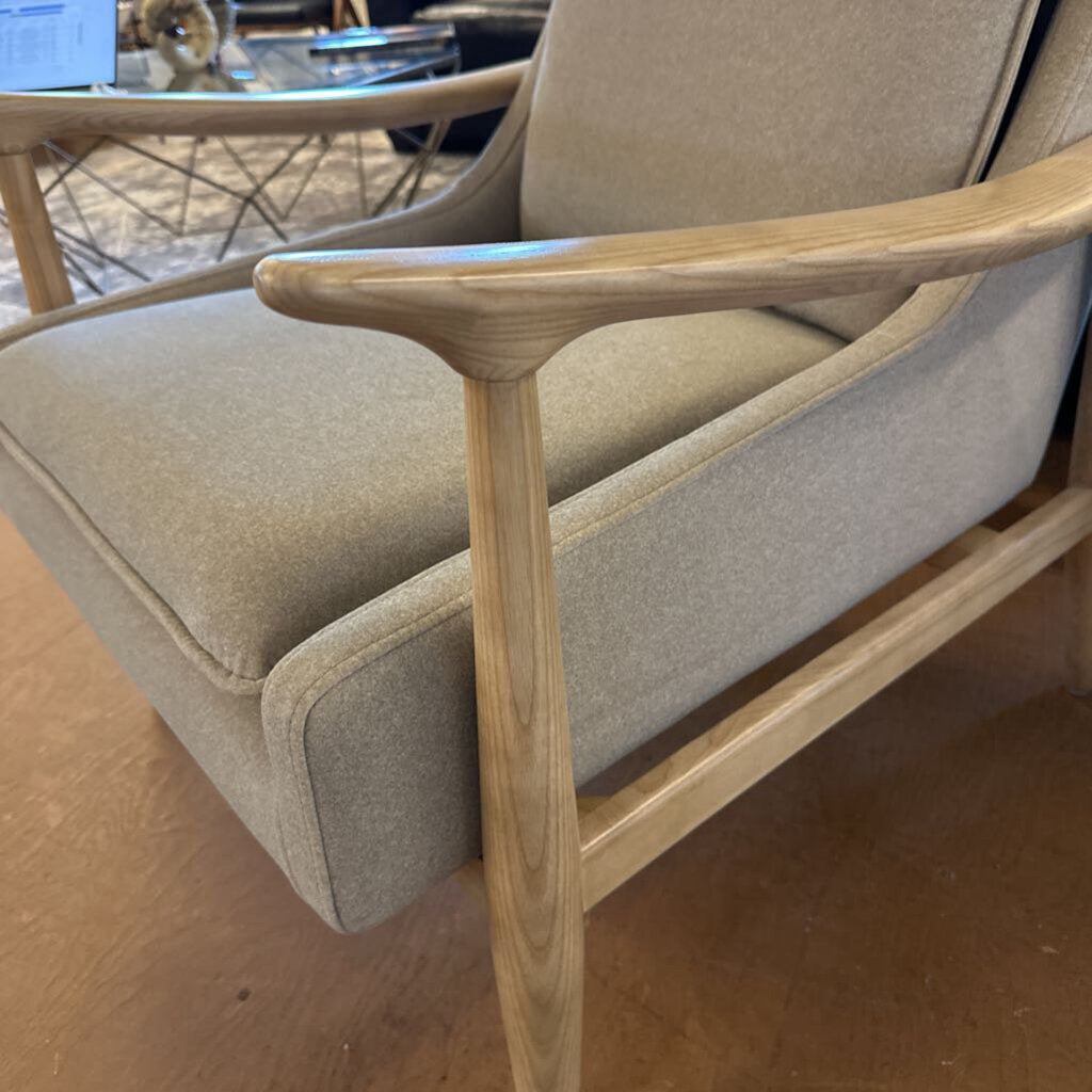 Beige armchair with wooden frame on a brown floor