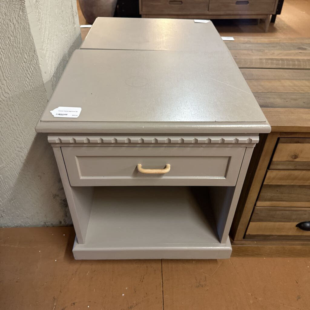 Gray side table with a drawer in a room setting