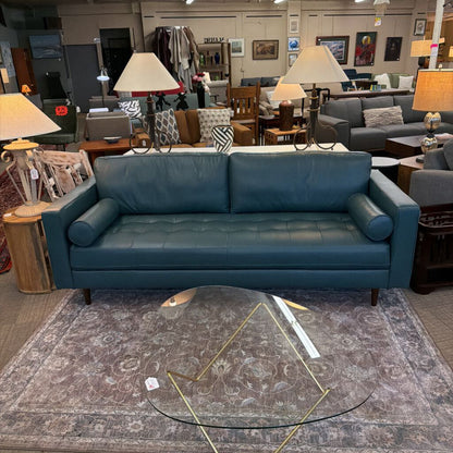 Blue sofa in a furniture store with various items in the background
