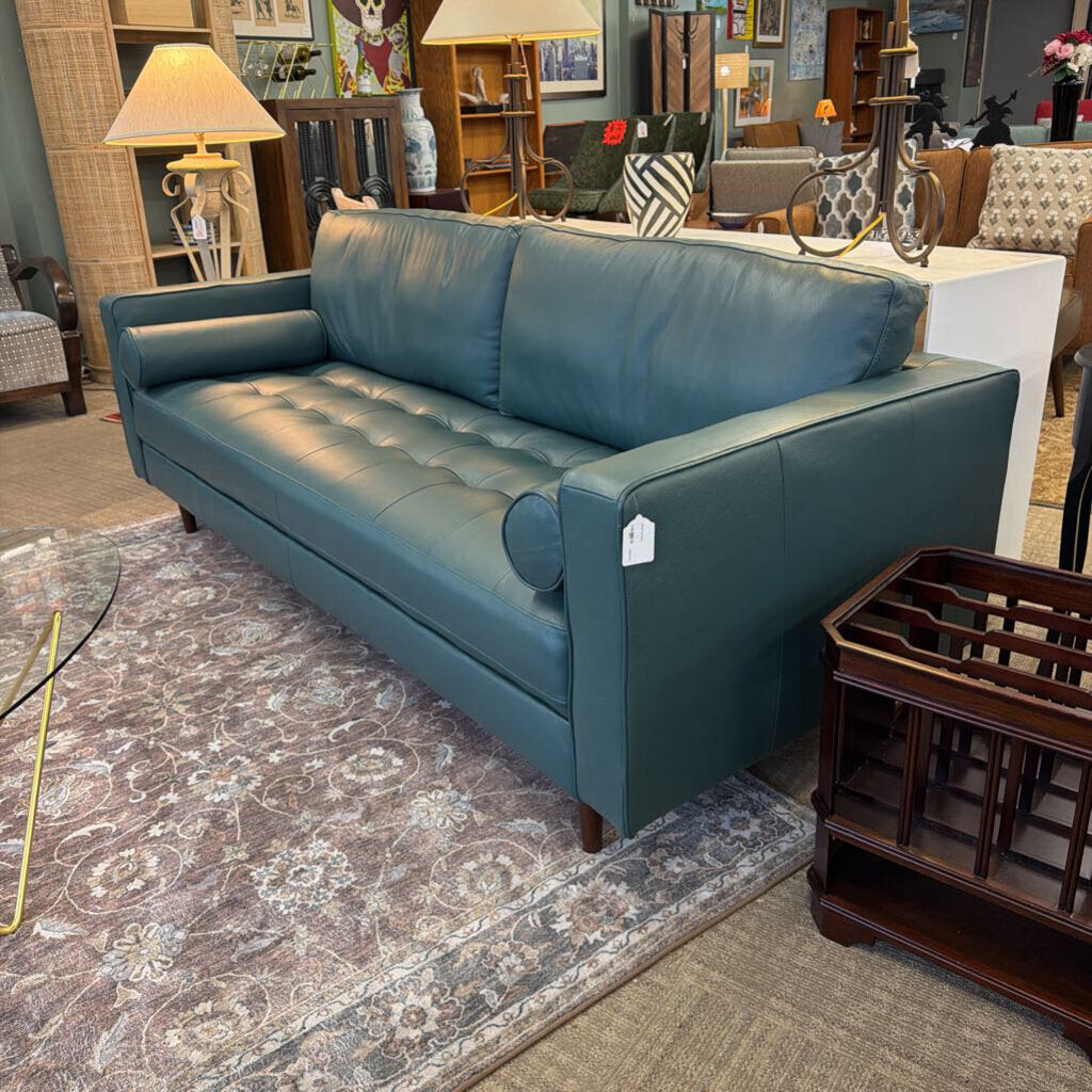 Blue sofa in a showroom with various furniture and decor items.