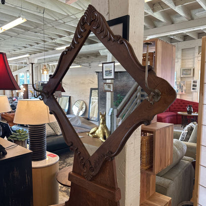 Decorative wooden mirror with intricate carvings in a living room setting.