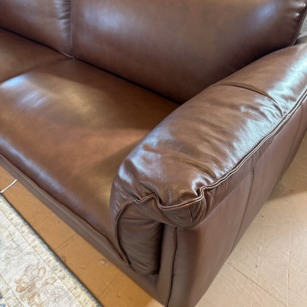 Brown leather sofa on a wooden floor