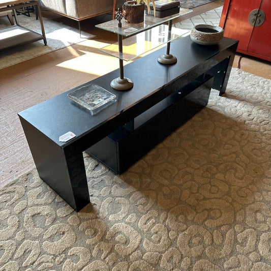 Black coffee table with decorative items in a living room setting