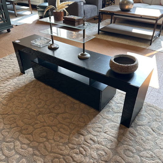 Black coffee table with decorative items in a living room setting