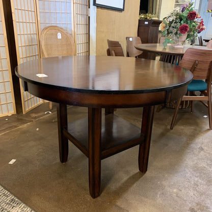Wooden dining table in a showroom setting with chairs and decor.