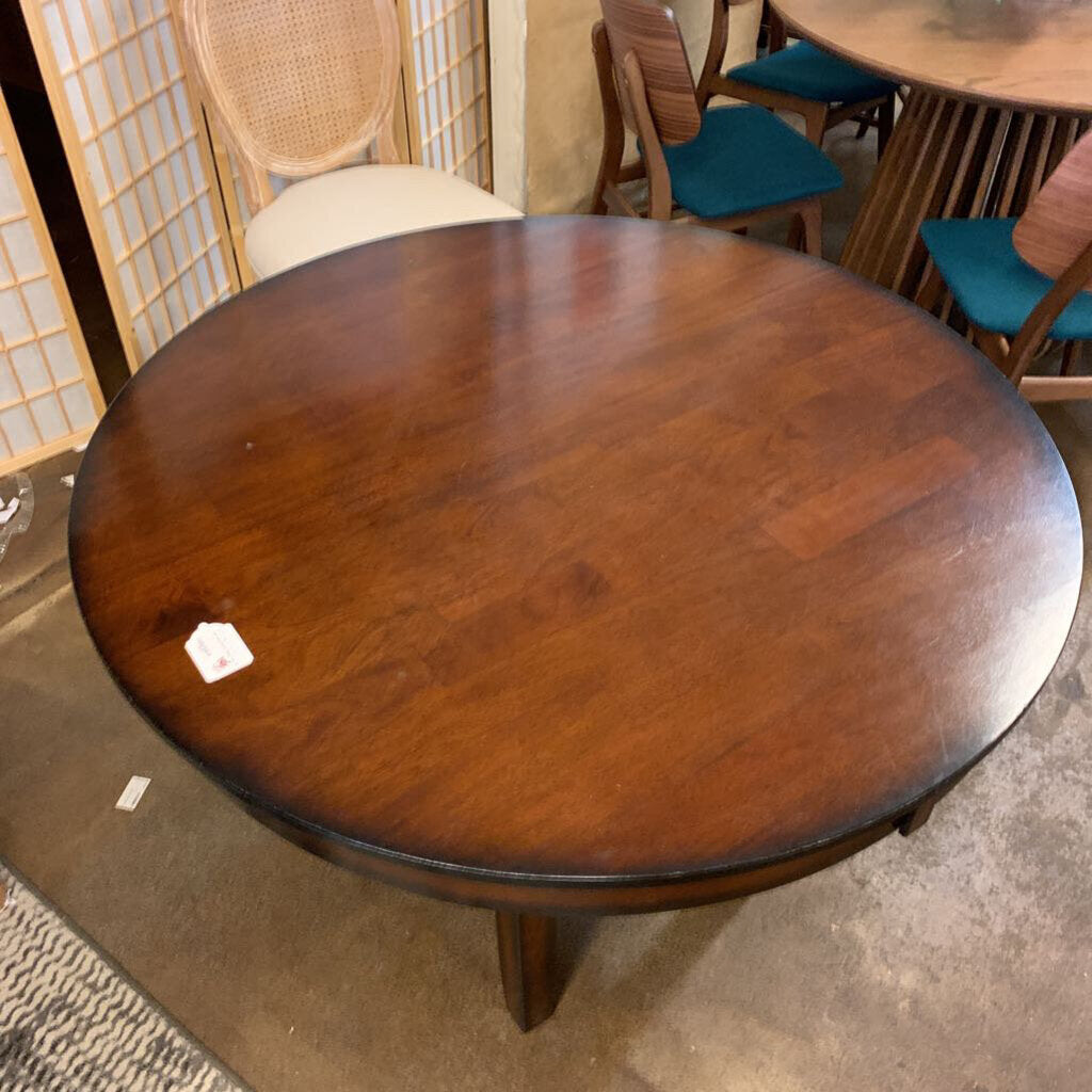 Round wooden table in a room with chairs and a rug