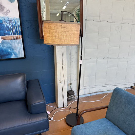 Futuristic lamp with wicker shade in a room with blue walls and a gray sofa.