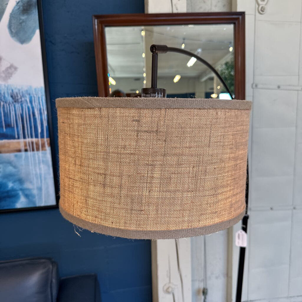 Textured lampshade in a room with a mirror and artwork on the wall.