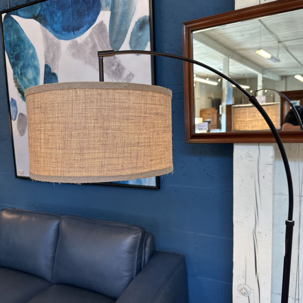 Living room with a blue sofa, lamp, and framed abstract art on a blue wall.