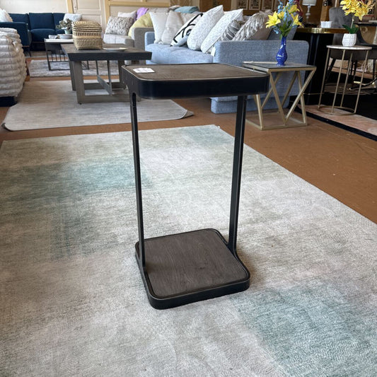 Small wooden side table with black metal legs in a living room setting.
