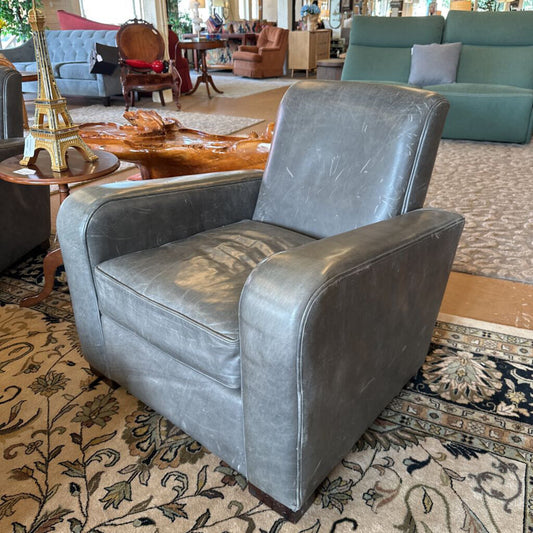 Gray armchair in a room with patterned carpet and furniture