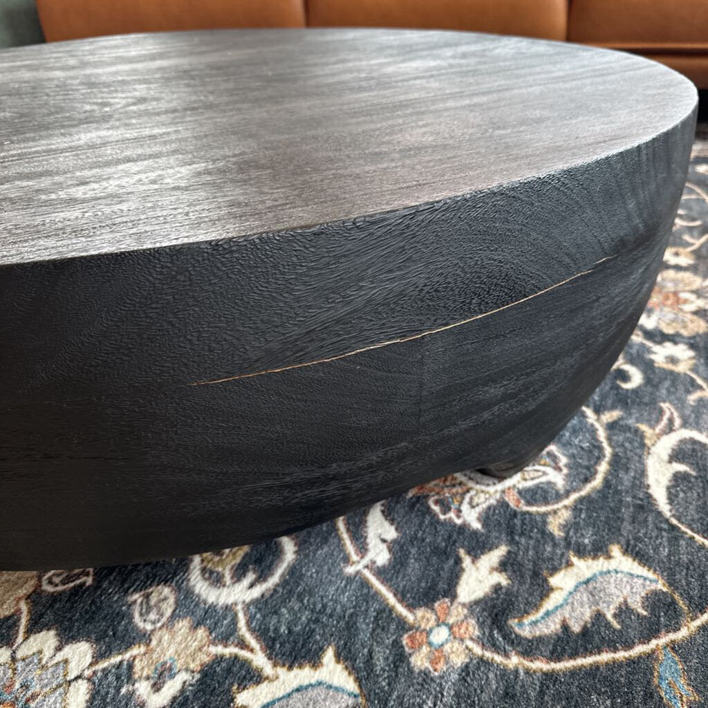 Round wooden table with a dark finish on a patterned rug