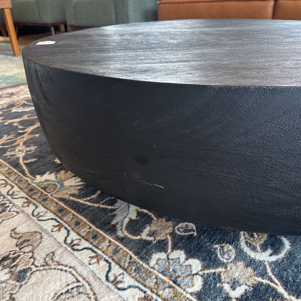 Round wooden coffee table on a patterned rug