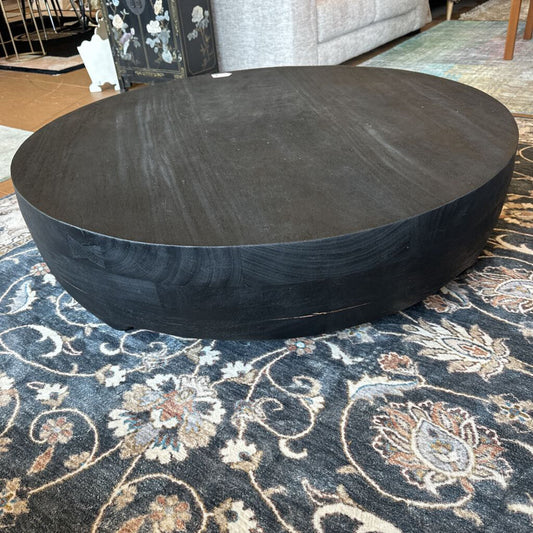 Round dark wood coffee table on a patterned rug