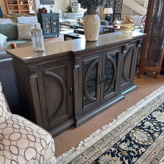 Wooden sideboard in a living room setting with decor items on top
