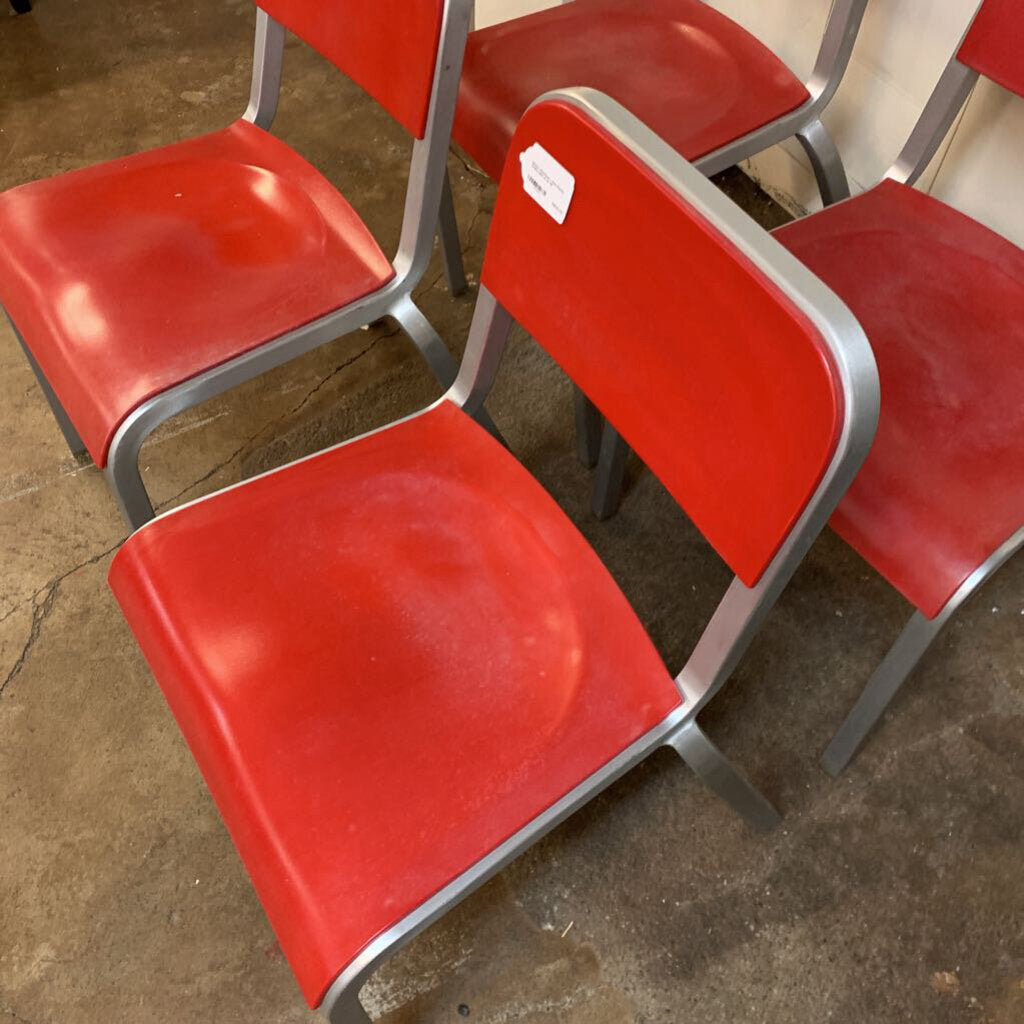Red chairs with metal legs on a concrete floor